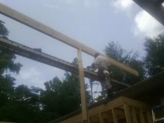 Carpenter setting a ridge beam over a new addition frame — Ice Dam Removal by Roofing Brothers in Pearsall