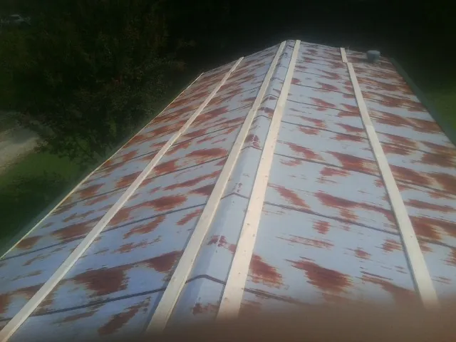 Rusted metal roof panels with new wood purlins before replacement — Storm Damage Roof Repair in Pearsall by Roofing Brothers