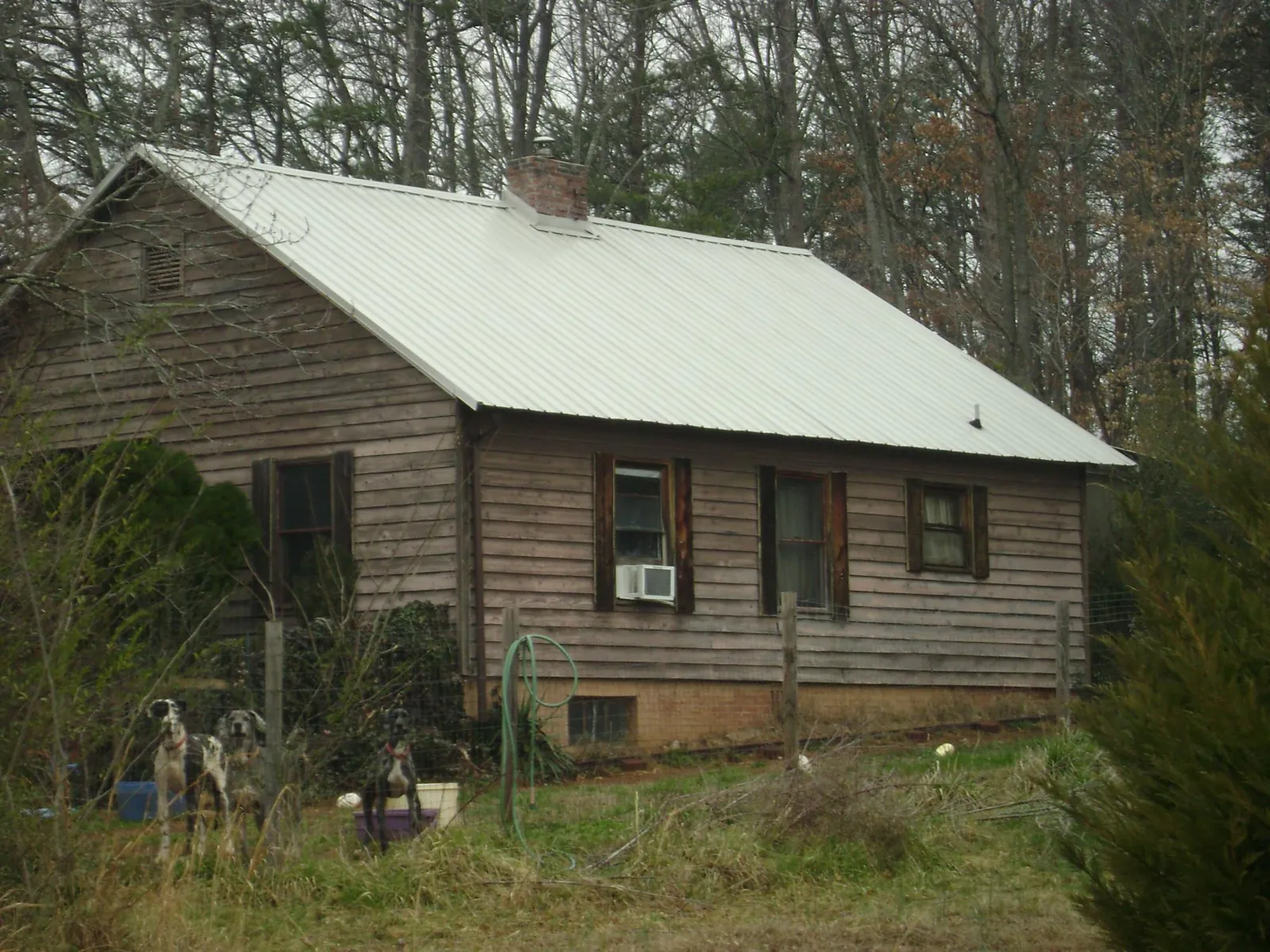 White metal roof on an old wood sided farmhouse, from a Metal Roof Installation job in Pearsall